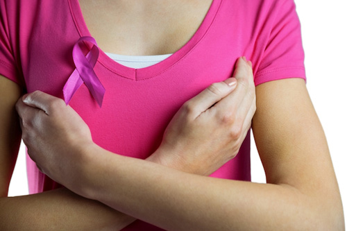 Mujer con un lazo rosa y los brazos cruzados en el pecho contra el cáncer de mama