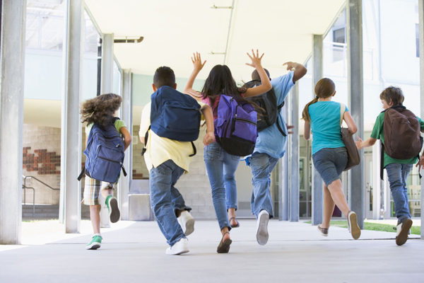 Niños saltando en un pasillo de un centro escolar