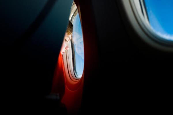 Niño en el avión mirando por la ventanilla