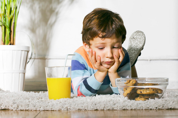 Niño mirando una merienda de cookies y zumo